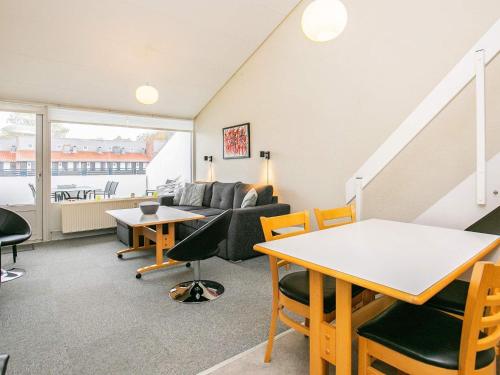 a living room with a couch and a table and chairs at 4 person holiday home on a holiday park in Faaborg in Fåborg