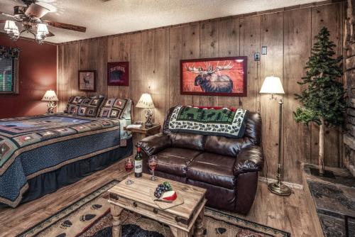 a bedroom with a bed and a leather couch at Shadow Mountain Lodge and Cabins in Ruidoso