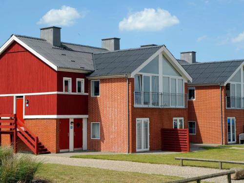 a red brick house with a black roof at 5 person holiday home on a holiday park in Lemvig in Lemvig
