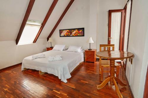 a bedroom with a bed and a table and a window at CasArte Takubamba B&B in Sucre