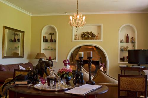 a living room with a table and a chandelier at Gerald's Gift Guest House in Addo