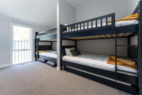 deux lits superposés dans une chambre avec fenêtre dans l'établissement Marysville Luxury Villa, à Marysville