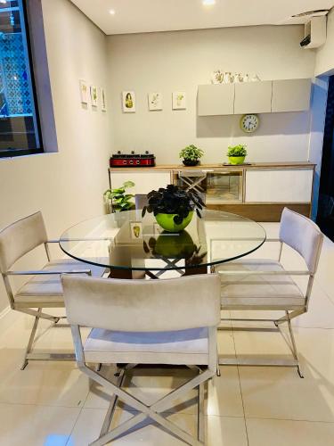 a dining room with a glass table and chairs at CWB 997 com piscina aquecida jacuzzi e Playground in Curitiba