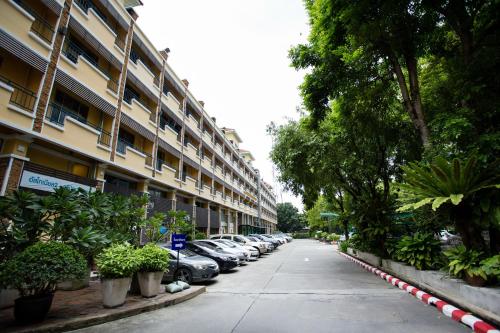 a parking lot with cars parked in front of a building at Paholyothin Park Place in Bangkok