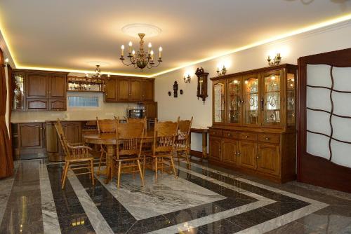 cocina con mesa, sillas y lámpara de araña en Gránit Villa en Balatonszárszó