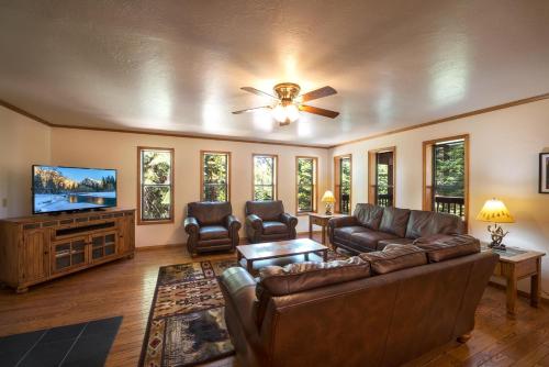 a living room with a couch and a flat screen tv at Quail Crossing Lodge in Yosemite West