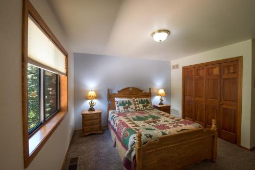 a bedroom with a bed and two lamps and a window at Quail Crossing Lodge in Yosemite West
