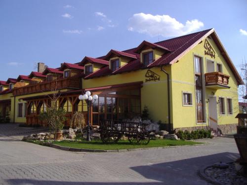 a large yellow building with a red roof at Penzión Salaš Cabaj in Nitra