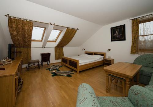a living room with a bed and a table and chairs at Penzión Salaš Cabaj in Nitra