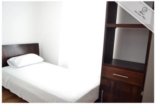 a bedroom with a bed and a book shelf at Hotel Quimbaya Plaza in Quimbaya