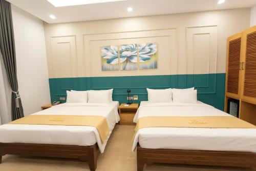 two beds in a room with green and white walls at La Casa Tuy Hòa in Tuy Hoa