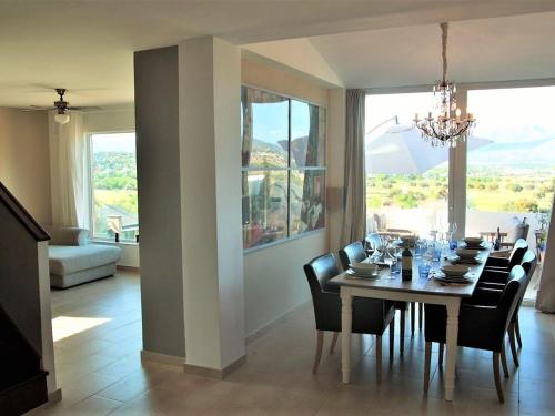 a dining room with a table with chairs and a chandelier at Belvilla by OYO Casa Alegr a in Galapagar