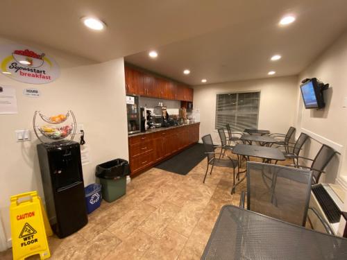 Super 8 by Wyndham 100 Mile House في One Hundred Mile House: مطعم بطاولة وكراسي ومطبخ