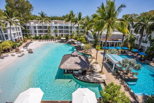 an aerial view of a resort pool with chairs and umbrellas at Beach Club Private Apartments Palm Cove in Palm Cove