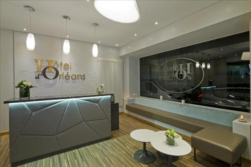 eine Lobby eines Hotels mit einem Tisch und Stühlen in der Unterkunft Hôtel d'Orléans in Orléans