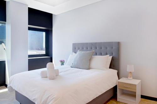 a bedroom with a large white bed and a window at City Explorer - 704 in Cape Town