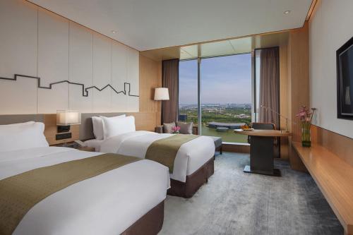 um quarto de hotel com duas camas e uma grande janela em Holiday Inn Nanjing Qinhuai South, an IHG Hotel em Jiangning