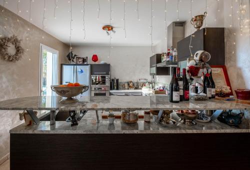 a kitchen with a counter top with bottles of wine at lamaison-d'ose in Romans