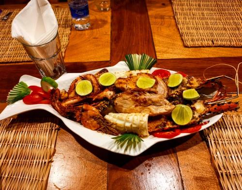a plate of food with lobster and corn on a table at Carpe Diem Nungwi in Nungwi
