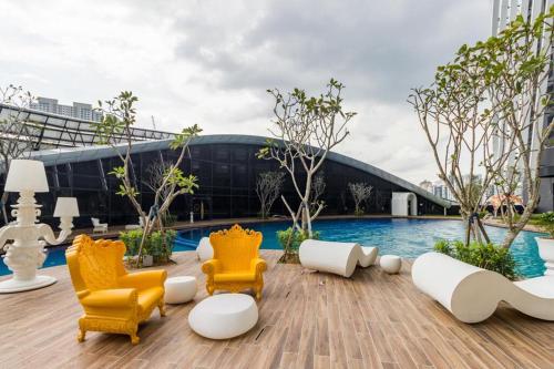 een patio met stoelen en een zwembad voor een gebouw bij Arte Mont Kiara by RKD HOME in Kuala Lumpur