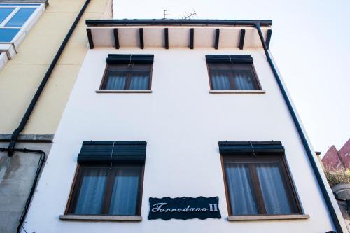 un edificio blanco con ventanas y un cartel en él en Casa Vacacional Torredano II en Nalda