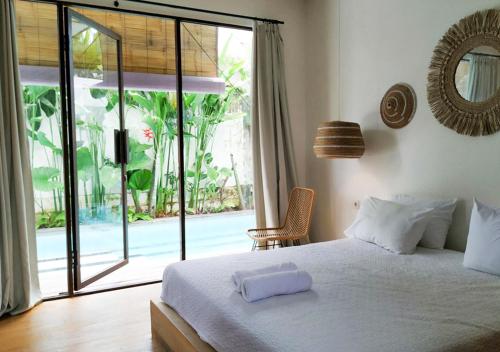 Tempat tidur dalam kamar di Villa Ubuntu by Optimum Bali Villas