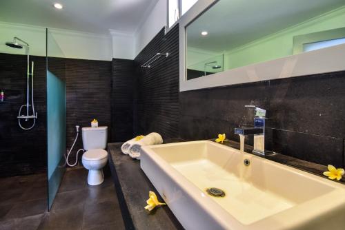a bathroom with a large tub and a toilet at Villa Coco in Temukus