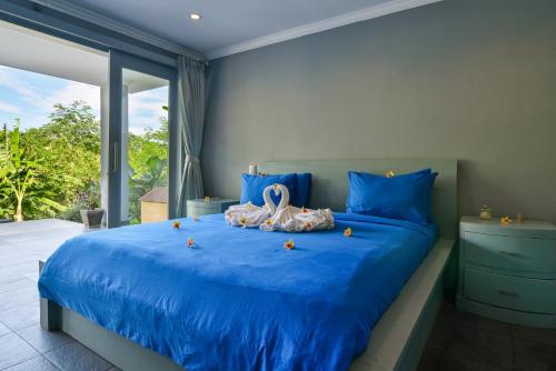 Un dormitorio con una cama azul con cisnes. en Villa Coco, en Temukus