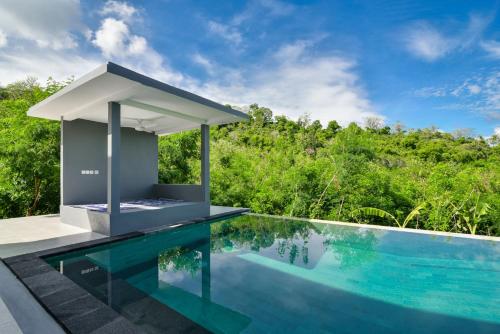 a swimming pool next to a villa with a swimming pool at Villa Coco in Temukus