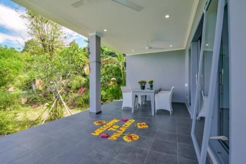 a porch with a table and flowers on the floor at Villa Coco in Temukus