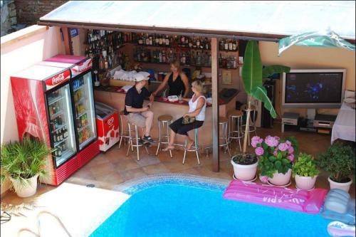 a group of people sitting at a table in a bar at Italia Hotel in Nesebar