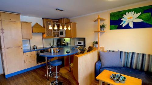 a kitchen and living room with a couch and a table at Himmelsbögen und Apartments mit Seeblick und Alleinlage in Weissensee