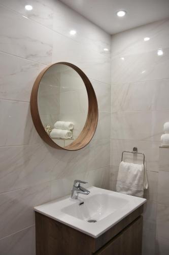ein Bad mit einem Waschbecken und einem Spiegel in der Unterkunft The Old Coffeehouse in Kalopanagiotis