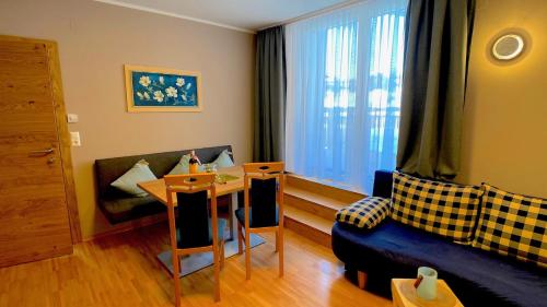 a small living room with a table and a couch at Himmelsbögen und Apartments mit Seeblick und Alleinlage in Weissensee