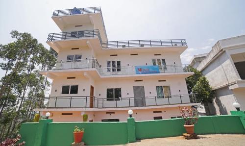un edificio con una recinzione verde di fronte ad esso di Treebo Trend Wanderlust Residency With Mountain View a Munnar