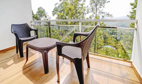 two chairs and a table on a balcony at Treebo Wanderlust Residency With Mountain View in Munnar