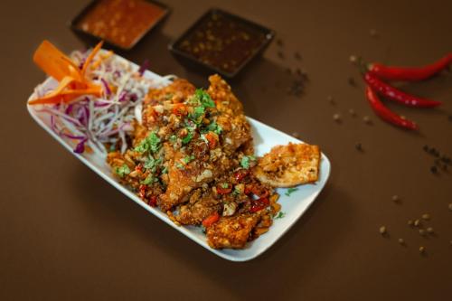 a plate of food on a table with food at Hotel Vdara in Vijayawāda