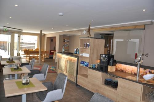 a restaurant with tables and chairs and a kitchen at Himmelsbögen und Apartments mit Seeblick und Alleinlage in Weissensee