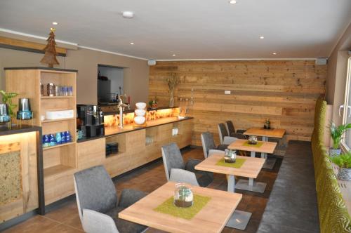 a restaurant with wooden walls and tables and chairs at Himmelsbögen und Apartments mit Seeblick und Alleinlage in Weissensee