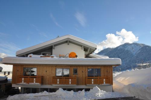 a house on a mountain with snow around it at Himmelsbögen und Apartments mit Seeblick und Alleinlage in Weissensee