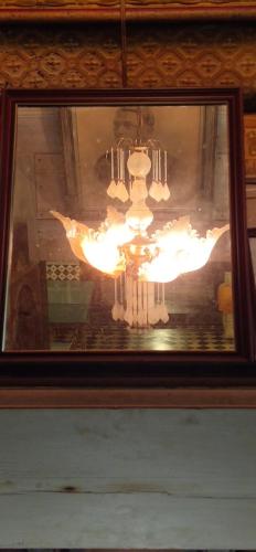 a picture of a chandelier in a painting at Chettinadu Mansion – An Authentic Heritage Palace in Kānādukāttān