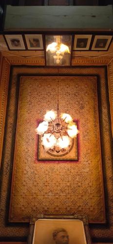 a chandelier hanging from a ceiling in a building at Chettinadu Mansion – An Authentic Heritage Palace in Kānādukāttān