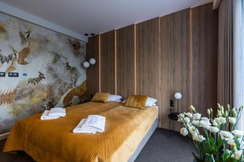 a bedroom with a bed with towels on it at Apartamenty Green Place in Kańczuga