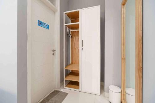 a bathroom with a closet with a toilet in it at Wisma KPBD Residence Syariah Mitra RedDoorz in Jakarta