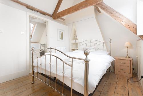 una camera con letto bianco e pavimento in legno di Driftwood Cottage pets go free WiFi included a Hunstanton