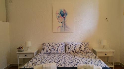 una camera da letto con un letto e un dipinto sul muro di Baia Santa Reparata, grazioso bilocale con vista mare - IUN Q2157 a Santa Teresa di Gallura