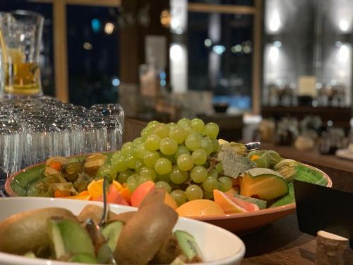 a table topped with two bowls of grapes and vegetables at Mountain Lodge in Stöten
