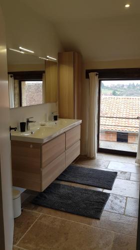 baño con lavabo y ventana grande en Les Peyronnies, en Figeac
