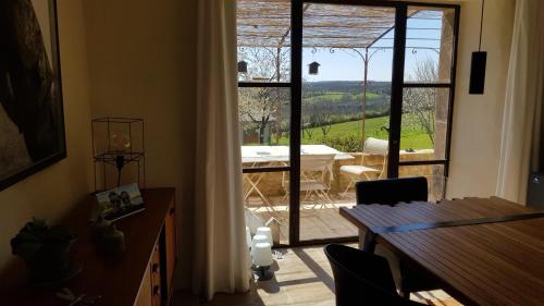 Cette chambre dispose d'une porte s'ouvrant sur une terrasse avec une table. dans l'établissement Les Peyronnies, à Figeac
