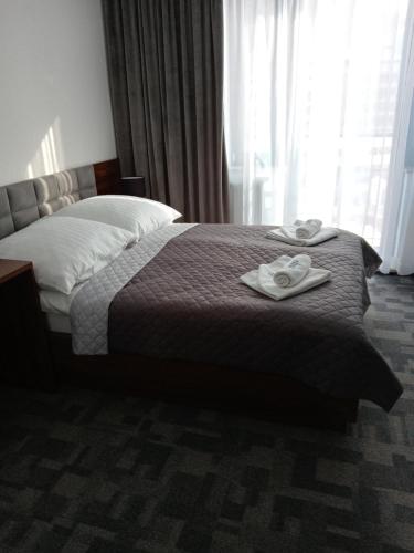 1 dormitorio con 1 cama con 2 toallas en Farys - świetna lokalizacja, sauna, jacuzzi, piękne widoki z okien, en Krynica-Zdrój